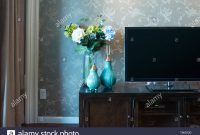 Two Elegant Vases With Flowers Near Tv In Modern Living Room in size 1300 X 956