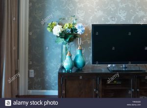 Two Elegant Vases With Flowers Near Tv In Modern Living Room in size 1300 X 956