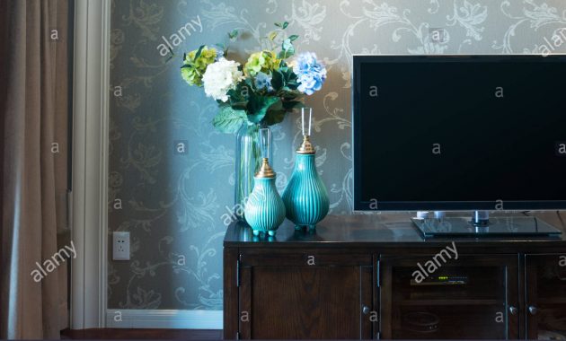 Two Elegant Vases With Flowers Near Tv In Modern Living Room in size 1300 X 956